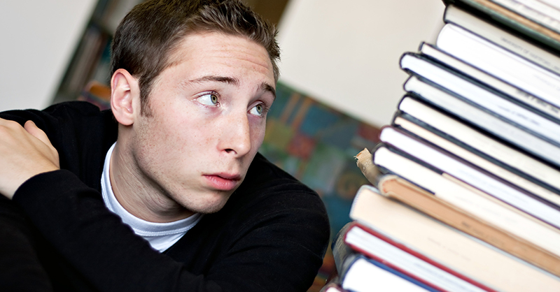 a-worried-student-looks-up-at-the-high-pile-of-textbooks-800.jpg